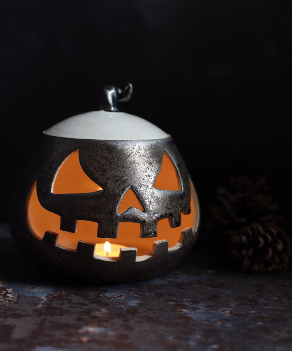 A glazed ceramic lantern pot with a Jack ‘o Lantern design from Glosters pottery classes.