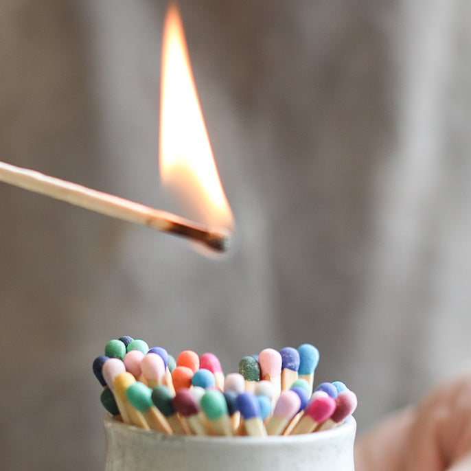 A ceramic match pot full of refilled matches.